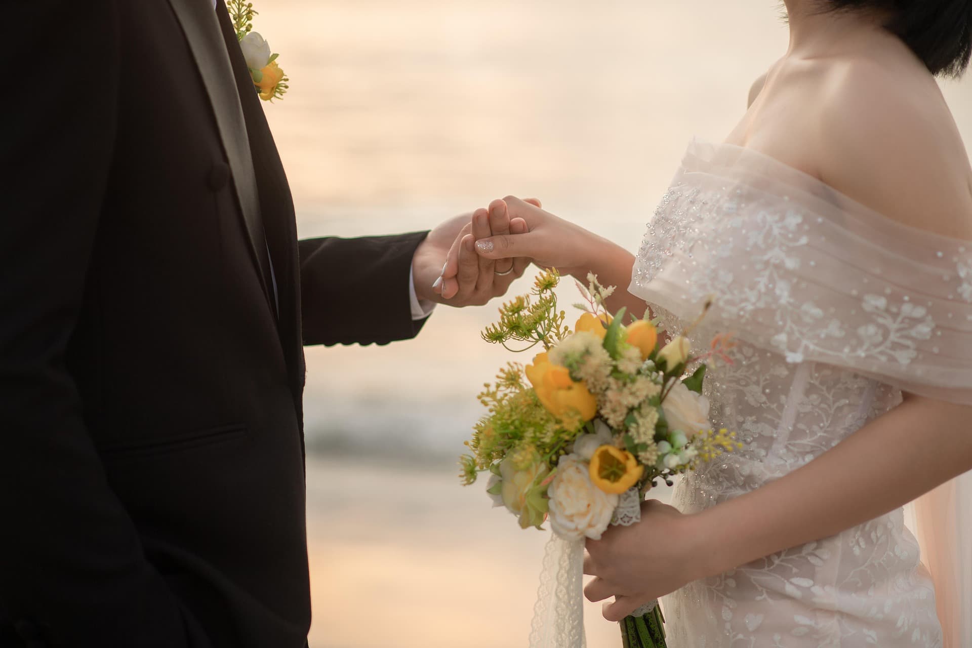 Groom holding bride's hand